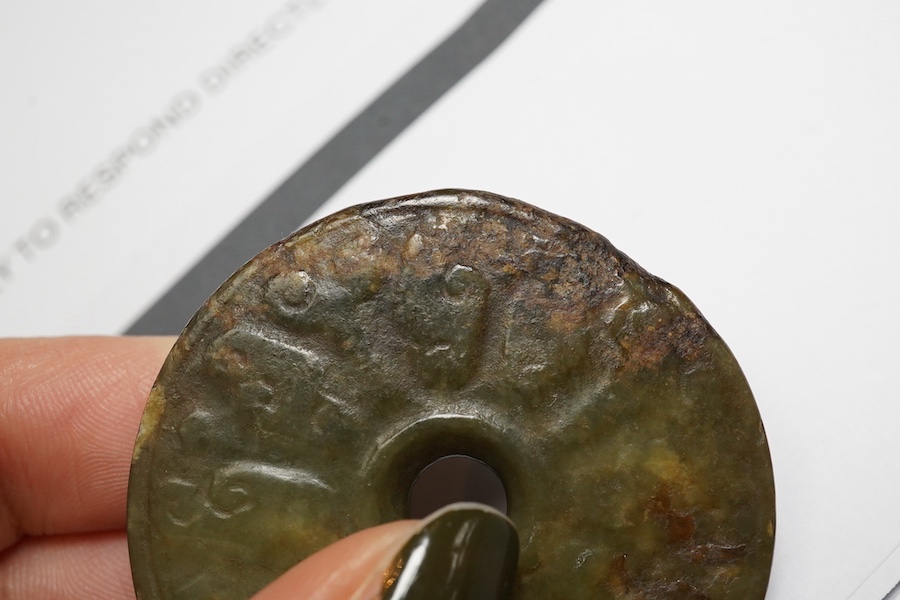 A Chinese green and brown jade bi disc, Yuan/Ming dynasty